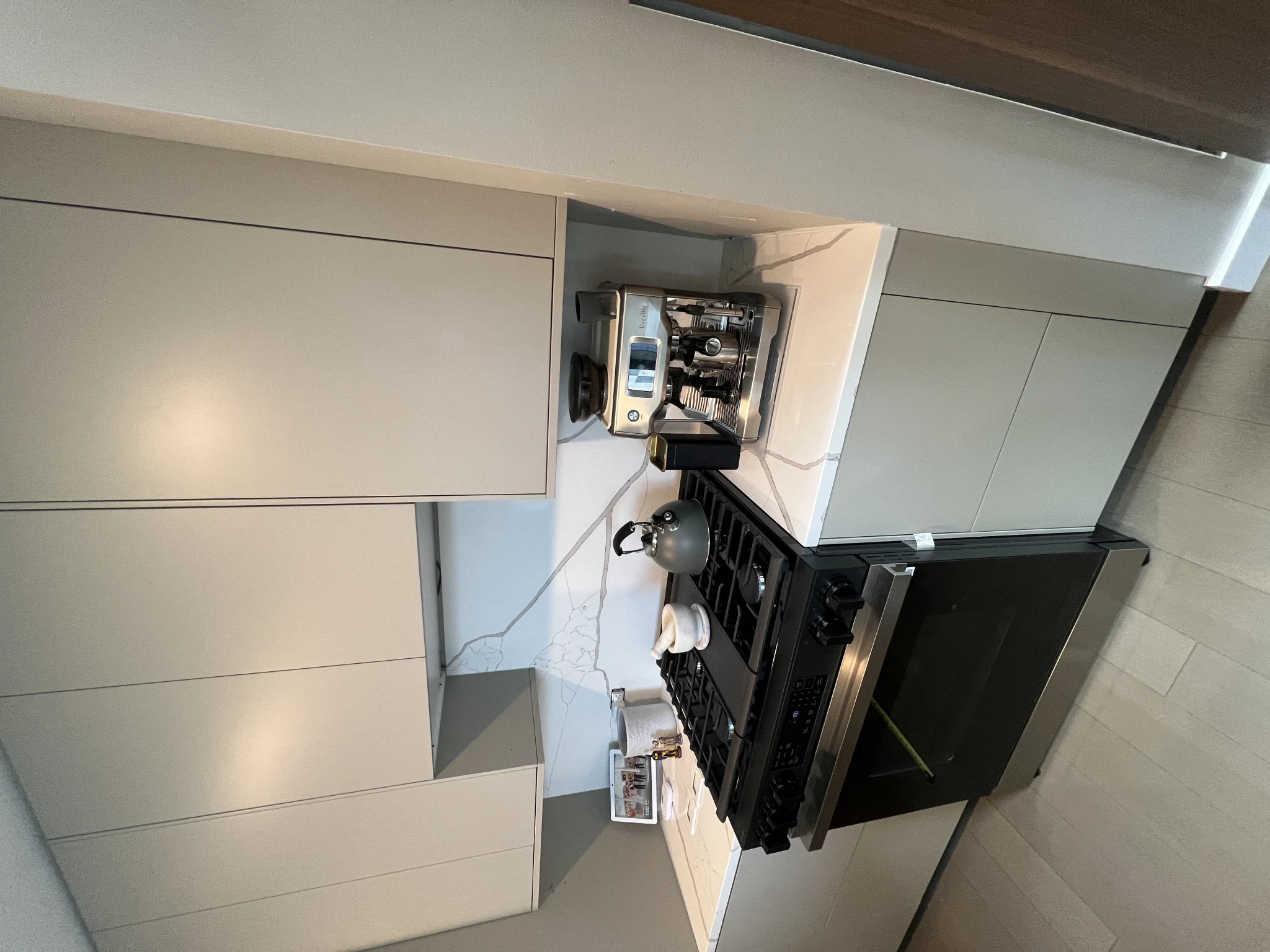 Completed IKEA kitchen installation with grey cabinets and professional gas range